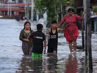 Residents of Kathmandu are wading through the floodwater along the embankment of the Bagmati River flowing through the capital after incessa...