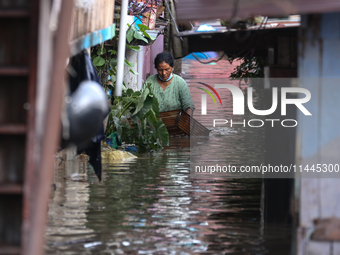 Residents of Kathmandu are wading through the floodwater along the embankment of the Bagmati River flowing through the capital after incessa...