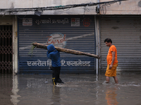 Residents of Kathmandu are wading through the floodwater along the embankment of the Bagmati River flowing through the capital after incessa...