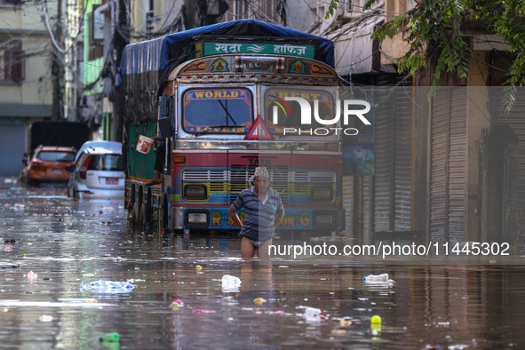 Residents of Kathmandu are wading through the floodwater along the embankment of the Bagmati River flowing through the capital after incessa...