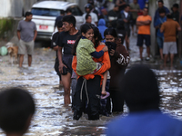 Residents of Kathmandu are wading through the floodwater along the embankment of the Bagmati River flowing through the capital after incessa...