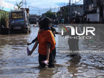 Residents of Kathmandu are wading through the floodwater along the embankment of the Bagmati River flowing through the capital after incessa...