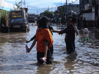 Residents of Kathmandu are wading through the floodwater along the embankment of the Bagmati River flowing through the capital after incessa...