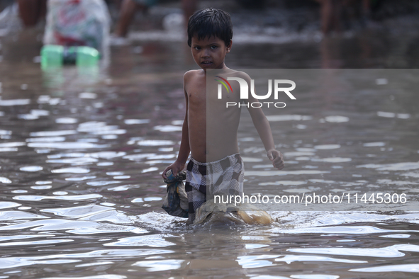 Residents of Kathmandu are wading through the floodwater along the embankment of the Bagmati River flowing through the capital after incessa...