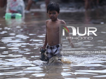 Residents of Kathmandu are wading through the floodwater along the embankment of the Bagmati River flowing through the capital after incessa...