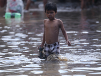 Residents of Kathmandu are wading through the floodwater along the embankment of the Bagmati River flowing through the capital after incessa...