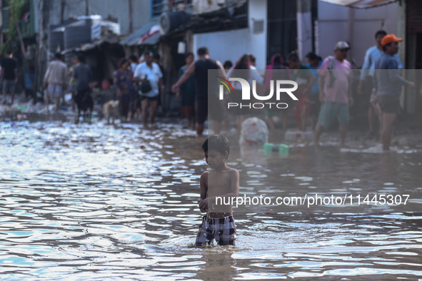 Residents of Kathmandu are wading through the floodwater along the embankment of the Bagmati River flowing through the capital after incessa...