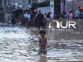 Residents of Kathmandu are wading through the floodwater along the embankment of the Bagmati River flowing through the capital after incessa...