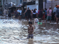 Residents of Kathmandu are wading through the floodwater along the embankment of the Bagmati River flowing through the capital after incessa...