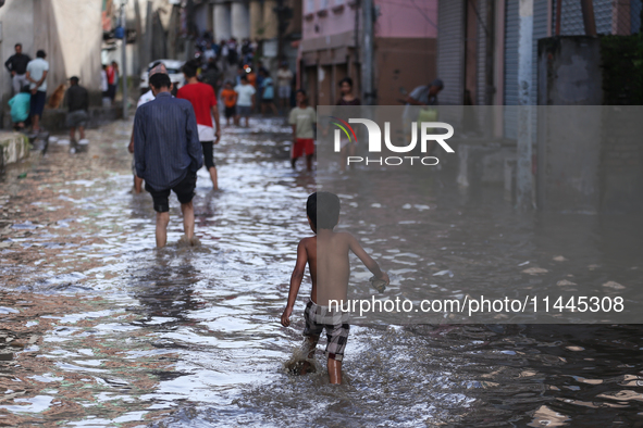 Residents of Kathmandu are wading through the floodwater along the embankment of the Bagmati River flowing through the capital after incessa...