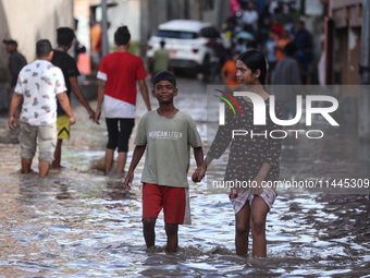 Residents of Kathmandu are wading through the floodwater along the embankment of the Bagmati River flowing through the capital after incessa...