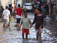 Residents of Kathmandu are wading through the floodwater along the embankment of the Bagmati River flowing through the capital after incessa...