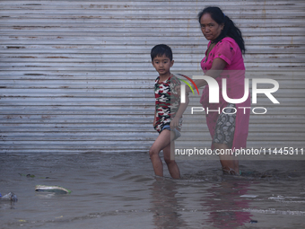 Residents of Kathmandu are wading through the floodwater along the embankment of the Bagmati River flowing through the capital after incessa...