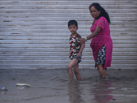 Residents of Kathmandu are wading through the floodwater along the embankment of the Bagmati River flowing through the capital after incessa...