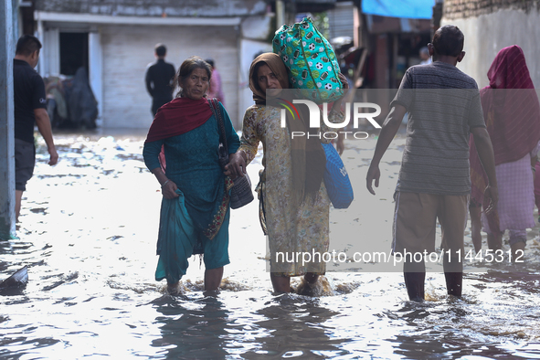 Residents of Kathmandu are wading through the floodwater along the embankment of the Bagmati River flowing through the capital after incessa...