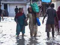 Residents of Kathmandu are wading through the floodwater along the embankment of the Bagmati River flowing through the capital after incessa...