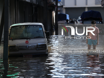 Residents of Kathmandu are wading through the floodwater along the embankment of the Bagmati River flowing through the capital after incessa...