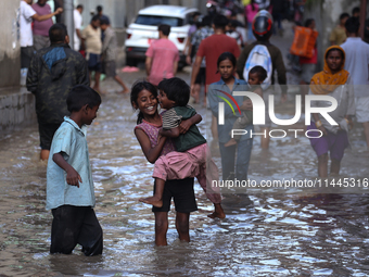 Residents of Kathmandu are wading through the floodwater along the embankment of the Bagmati River flowing through the capital after incessa...