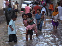 Residents of Kathmandu are wading through the floodwater along the embankment of the Bagmati River flowing through the capital after incessa...