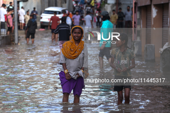 Residents of Kathmandu are wading through the floodwater along the embankment of the Bagmati River flowing through the capital after incessa...