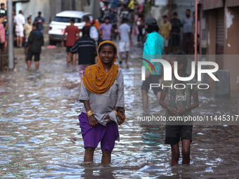 Residents of Kathmandu are wading through the floodwater along the embankment of the Bagmati River flowing through the capital after incessa...