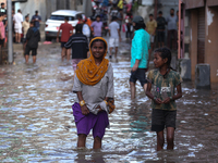 Residents of Kathmandu are wading through the floodwater along the embankment of the Bagmati River flowing through the capital after incessa...