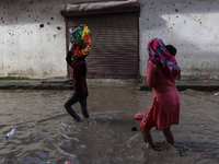 Residents of Kathmandu are wading through the floodwater along the embankment of the Bagmati River flowing through the capital after incessa...