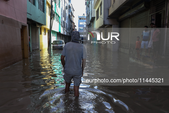 Residents of Kathmandu are wading through the floodwater along the embankment of the Bagmati River flowing through the capital after incessa...