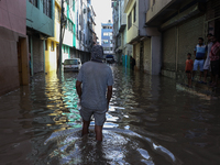 Residents of Kathmandu are wading through the floodwater along the embankment of the Bagmati River flowing through the capital after incessa...