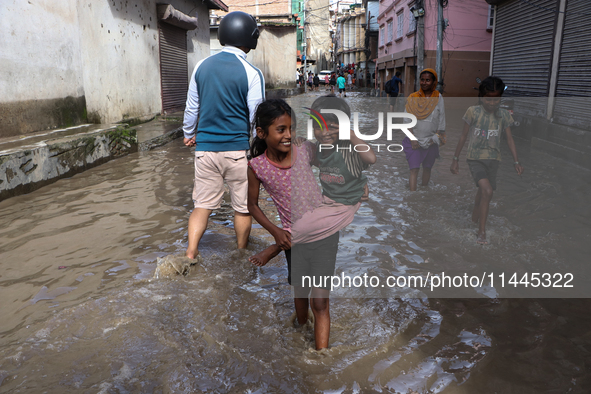 Residents of Kathmandu are wading through the floodwater along the embankment of the Bagmati River flowing through the capital after incessa...