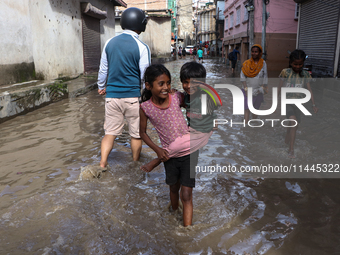 Residents of Kathmandu are wading through the floodwater along the embankment of the Bagmati River flowing through the capital after incessa...