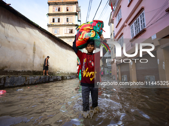 People are wading through the flood in a slum in Kathmandu, Nepal, on July 31, 2024. (