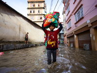 People are wading through the flood in a slum in Kathmandu, Nepal, on July 31, 2024. (