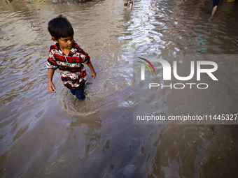 People are wading through the flood in a slum in Kathmandu, Nepal, on July 31, 2024. (