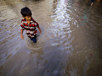 People are wading through the flood in a slum in Kathmandu, Nepal, on July 31, 2024. (