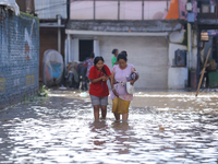 People are wading through the flood in a slum in Kathmandu, Nepal, on July 31, 2024. (