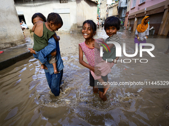 People are wading through the flood in a slum in Kathmandu, Nepal, on July 6, 2024 (