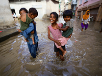 People are wading through the flood in a slum in Kathmandu, Nepal, on July 6, 2024 (