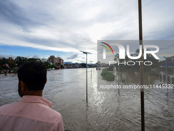 Nepali citizens are watching the rising level of Bagmati River in Kathmandu, Nepal, on July 31, 2024. (