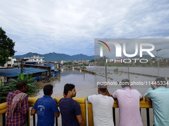 Nepali citizens are watching the rising level of Bagmati River in Kathmandu, Nepal, on July 31, 2024. (