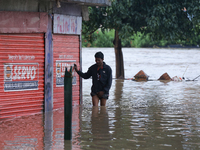 A Nepali man is wading through the flooded water in Nepal on July 31, 2024. (