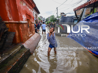 People are wading through the flood in a slum in Kathmandu, Nepal, on July 31, 2024. (