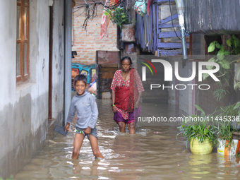 People are wading through the flood in a slum in Kathmandu, Nepal, on July 31, 2024. (