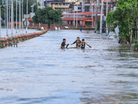 People are wading through the flood in a slum in Kathmandu, Nepal, on July 31, 2024. (