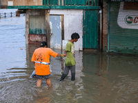 People are wading through the flood in a slum in Kathmandu, Nepal, on July 31, 2024. (