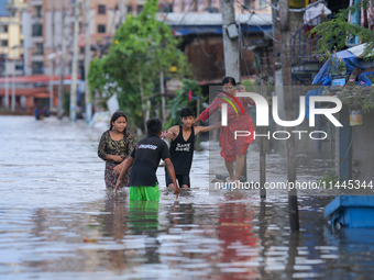 People are wading through the flood in a slum in Kathmandu, Nepal, on July 31, 2024. (