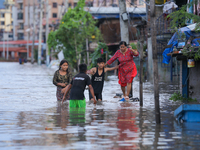 People are wading through the flood in a slum in Kathmandu, Nepal, on July 31, 2024. (