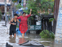 People are wading through the flood in a slum in Kathmandu, Nepal, on July 31, 2024. (