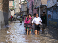 People are wading through the flood in a slum in Kathmandu, Nepal, on July 31, 2024. (