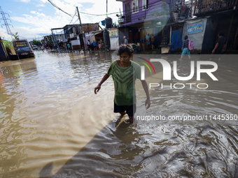 A Nepali man is wading through the flooded water in Nepal on July 31, 2024. (